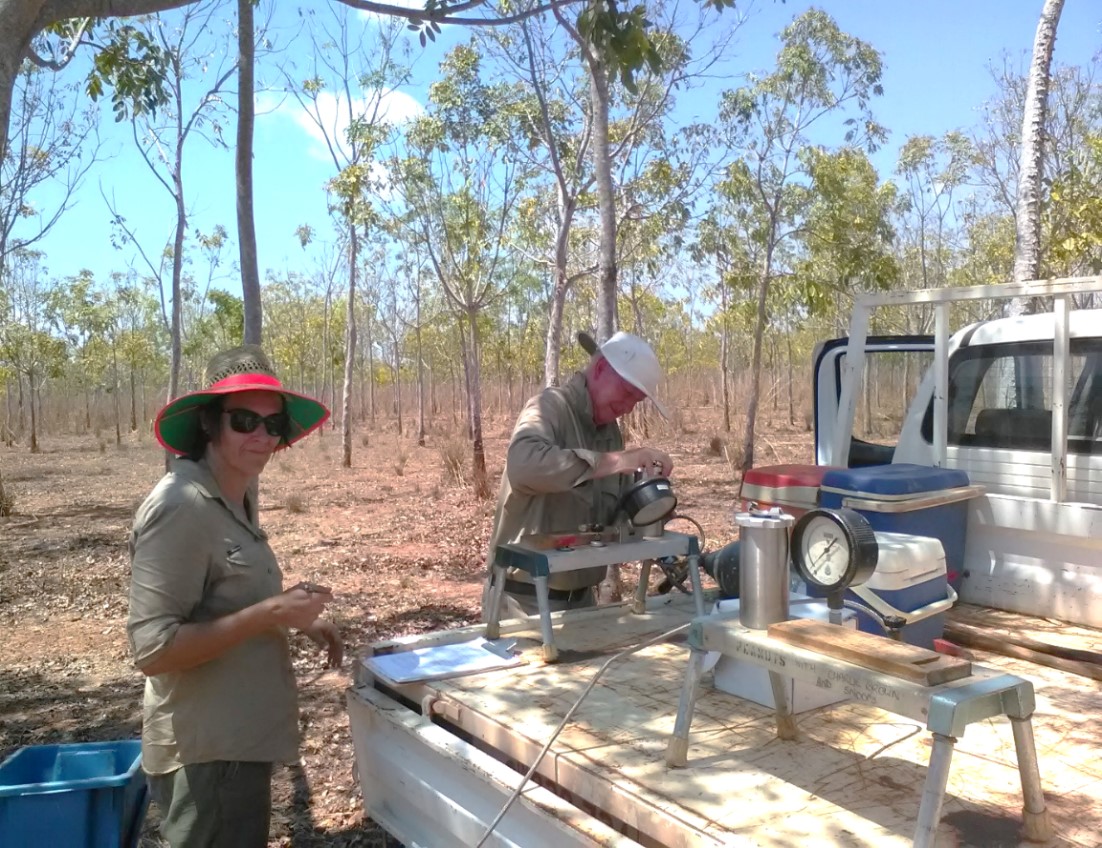 Figure 11. Dallas Anson (L) and John McGrath (R) measure midday leaf water status of mahogany in the ‘back of the ute field lab’, Douglas Daly. (Note the thin tree crowns in the plantation at the end of the dry season due to the seasonal shedding of leaves as the trees become water stressed)