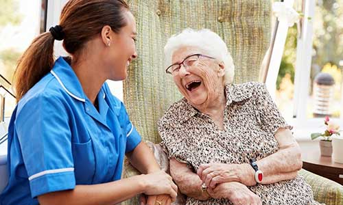Nurse laughing with an elderly woman